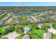 A picturesque aerial view showcases a residential neighborhood with a serene lake and lush green landscaping at 14817 Deerwood Dr, Carmel, IN 46033