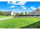 Wide backyard with a white fence, green grass, and clear blue skies at 14817 Deerwood Dr, Carmel, IN 46033