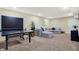 Basement with ping pong table, neutral carpet, recessed lighting and cozy seating area with gray sectional at 14817 Deerwood Dr, Carmel, IN 46033