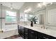 Bathroom with a double vanity, a wide mirror, and a tub in the background at 14817 Deerwood Dr, Carmel, IN 46033