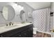 Bathroom with double vanity, marble countertop, and patterned shower curtain at 14817 Deerwood Dr, Carmel, IN 46033