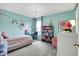 Charming bedroom with a floral bedspread, colorful decor, and a cozy study area at 14817 Deerwood Dr, Carmel, IN 46033