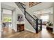Inviting foyer with hardwood floors, staircase with ornate railings, and views into the living and dining areas at 14817 Deerwood Dr, Carmel, IN 46033