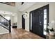 Elegant foyer showcasing hardwood floors, a staircase with black iron railings, and a stylish front door with sidelights at 14817 Deerwood Dr, Carmel, IN 46033