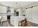 Well-lit kitchen boasts white cabinetry, stainless steel appliances, an island with bar seating, and a sliding barn door at 14817 Deerwood Dr, Carmel, IN 46033