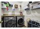 Functional laundry room features shelving, counter space, and modern washer and dryer units at 14817 Deerwood Dr, Carmel, IN 46033