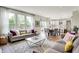 Bright living room with large windows, open to the kitchen, and hardwood floors at 14817 Deerwood Dr, Carmel, IN 46033