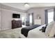 Stylish main bedroom with a mounted TV, dual windows, and sophisticated decor at 14817 Deerwood Dr, Carmel, IN 46033