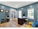 Stylish home office featuring hardwood floors, natural light from large windows, and a modern desk setup at 14817 Deerwood Dr, Carmel, IN 46033