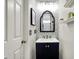 Stylish powder room with patterned wallpaper, modern fixtures, and a sleek vanity with framed mirror at 14817 Deerwood Dr, Carmel, IN 46033