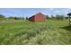 Barn with a dark red exterior and surrounding field at 1598 Commerce Way, Pittsboro, IN 46167