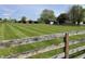 Exterior home view with a large grassy field, wooden fence, with barn and garage at 1598 Commerce Way, Pittsboro, IN 46167