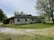 Side view of home featuring a large yard and mature tree at 1598 Commerce Way, Pittsboro, IN 46167