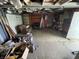 Unfinished garage interior with concrete floors, shelving, a chair, and exposed structure at 1598 Commerce Way, Pittsboro, IN 46167