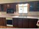 Kitchen featuring wood cabinets, white countertops, a sink and a microwave at 1598 Commerce Way, Pittsboro, IN 46167
