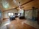 Open-concept living room with wood floors, stone fireplace, ceiling fans, and a view of the kitchen at 1598 Commerce Way, Pittsboro, IN 46167