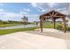 Backyard with a pond view, pergola, concrete patio, rock landscaping and green grass at 17023 Adler Ln, Noblesville, IN 46060