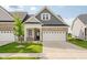 Beautiful two-story home featuring a manicured lawn, charming brick facade, and attached two-car garage at 17023 Adler Ln, Noblesville, IN 46060