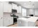 Bright kitchen features white cabinets, stainless steel appliances, quartz countertops and a view to the living area at 17023 Adler Ln, Noblesville, IN 46060