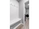 Mudroom with white bench and hooks, and view into the laundry room with washer and dryer at 17023 Adler Ln, Noblesville, IN 46060