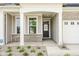 Inviting front porch featuring brick accents, a decorative front door, and manicured landscaping at 17023 Adler Ln, Noblesville, IN 46060