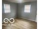A bedroom with vinyl flooring and two windows at 1710 S Birch St, Muncie, IN 47302