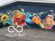 Artistic painting on the exterior of commercial building with colorful birds, sunflowers and butterfly at 1710 S Birch St, Muncie, IN 47302