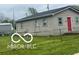 Single-story home features light siding, a fenced front yard, and ample greenery at 1710 S Birch St, Muncie, IN 47302