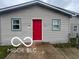 Close up of a single-story home's light siding and red front door at 1710 S Birch St, Muncie, IN 47302