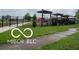 Community playground with a black metal fence and mature green grass lawn at 1710 S Birch St, Muncie, IN 47302