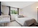 This bedroom features a crib, a large window, and neutral tones at 1715 Haynes Ave, Indianapolis, IN 46240
