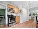 The kitchen features wood cabinets, stainless steel appliances, and wood-look flooring at 1715 Haynes Ave, Indianapolis, IN 46240