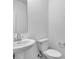 Clean bathroom featuring a pedestal sink, toilet, and modern fixtures at 17344 Hanningfield Way, Westfield, IN 46074