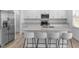 A sleek, white kitchen with stainless steel appliances, granite countertops and seating for four at 17344 Hanningfield Way, Westfield, IN 46074