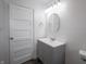 A white bathroom features a gray vanity, sink, mirror, and toilet at 204 N Vine St, Shelbyville, IN 46176