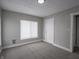 A gray toned bedroom features neutral carpet, a window, and trim at 204 N Vine St, Shelbyville, IN 46176