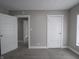 A gray toned bedroom features neutral carpet, two doors, and trim at 204 N Vine St, Shelbyville, IN 46176