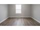 Bright empty bedroom with freshly painted walls, new floors, and natural light from a large window at 204 N Vine St, Shelbyville, IN 46176