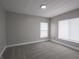 A gray toned bedroom features neutral carpet, two windows, and trim at 204 N Vine St, Shelbyville, IN 46176