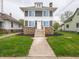 Gray two-story home with a stone facade and landscaped front yard, including a well-maintained lawn and walkway at 204 N Vine St, Shelbyville, IN 46176