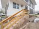 Exterior view of a home with gray stucco, white trim, and wooden steps leading to an entrance at 204 N Vine St, Shelbyville, IN 46176