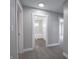Hallway with carpet flooring that opens to a bathroom with white tiled walls and a white tub at 204 N Vine St, Shelbyville, IN 46176