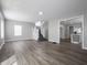Bright, spacious living room featuring new wood flooring, fresh paint, and a staircase at 204 N Vine St, Shelbyville, IN 46176