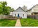 Backyard featuring a detached garage, wooden deck with picnic table, lush green grass, and fencing at 2237 N New Jersey St, Indianapolis, IN 46205