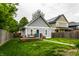 Backyard featuring a detached garage, wooden deck with picnic table, lush green grass, and fencing at 2237 N New Jersey St, Indianapolis, IN 46205