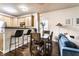 Charming dining area with wooden table, bar seating, and pendant lighting adjacent to the modern kitchen at 2237 N New Jersey St, Indianapolis, IN 46205