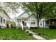 Charming home with a blue door, covered front porch and welcoming curb appeal on a bright, sunny day at 2237 N New Jersey St, Indianapolis, IN 46205