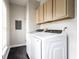 Bright laundry room featuring a modern washer and dryer, overhead cabinets, and neutral wall color at 2237 N New Jersey St, Indianapolis, IN 46205