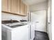 Bright laundry room featuring a modern washer and dryer, overhead cabinets, and neutral wall color at 2237 N New Jersey St, Indianapolis, IN 46205