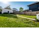 Expansive, well-maintained back yard with lush green grass, a concrete path, and privacy fencing at 2251 N New Jersey St, Indianapolis, IN 46205